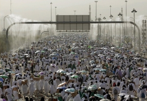 Water vapour sprays down from metal pipes to cool the crowd